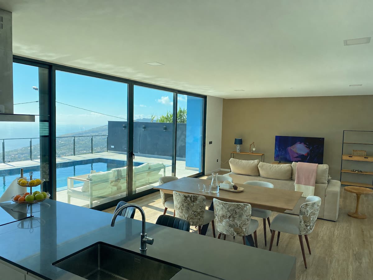Sala e cozinha abertas com vista para o mar