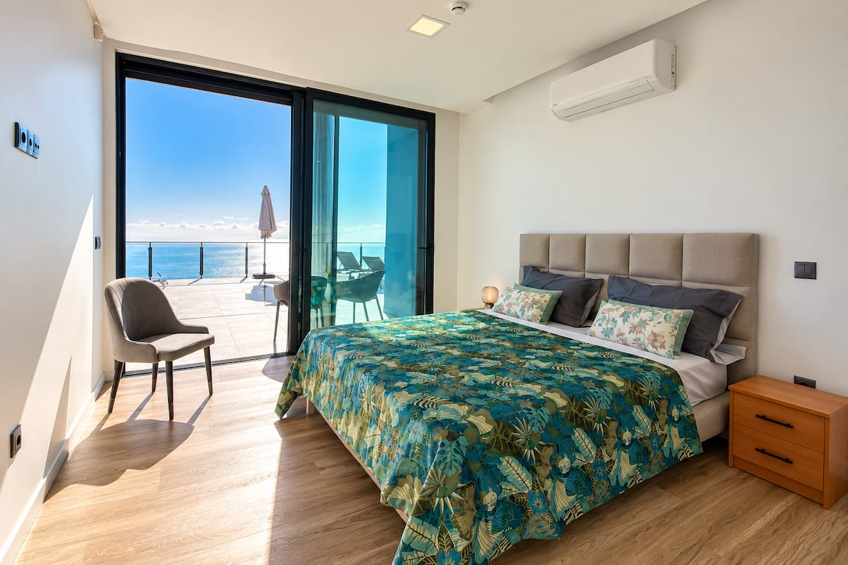 Segundo quarto com cama queen size e vista de mar